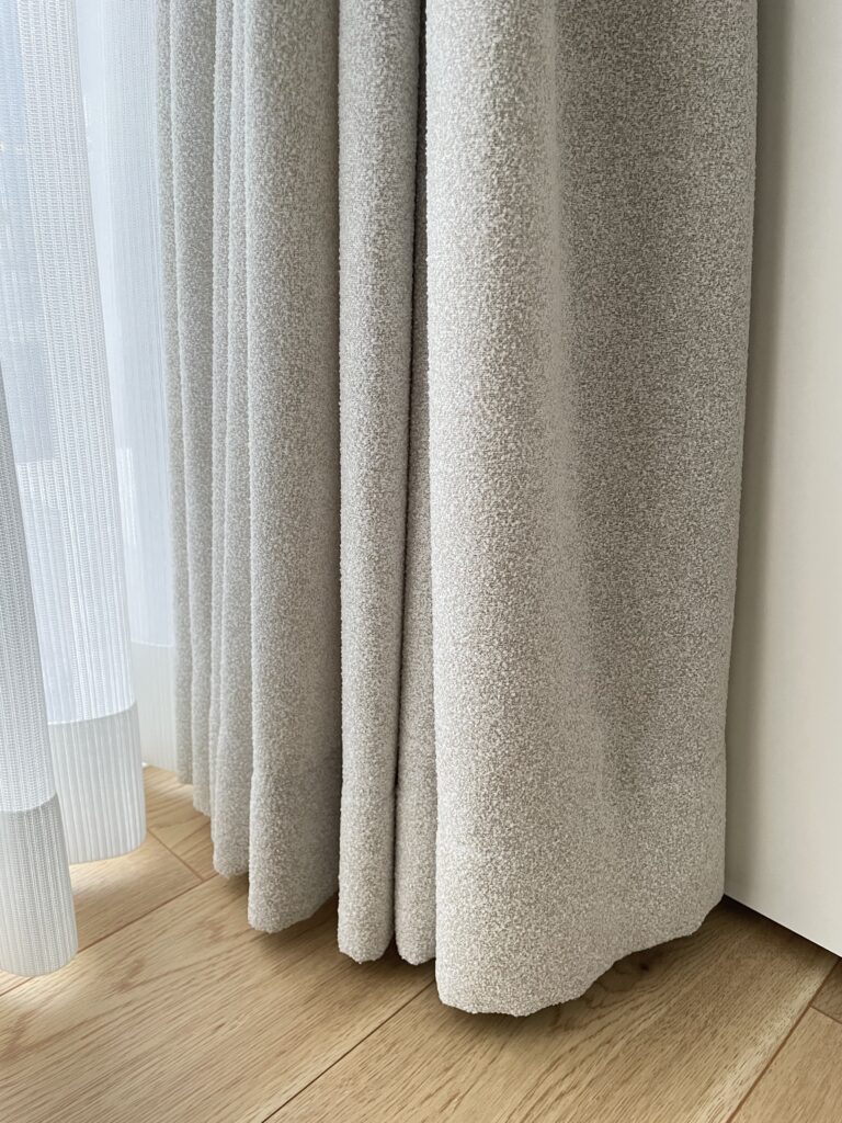 カーテンの裾の写真（ベージュ、プリーツの部分）