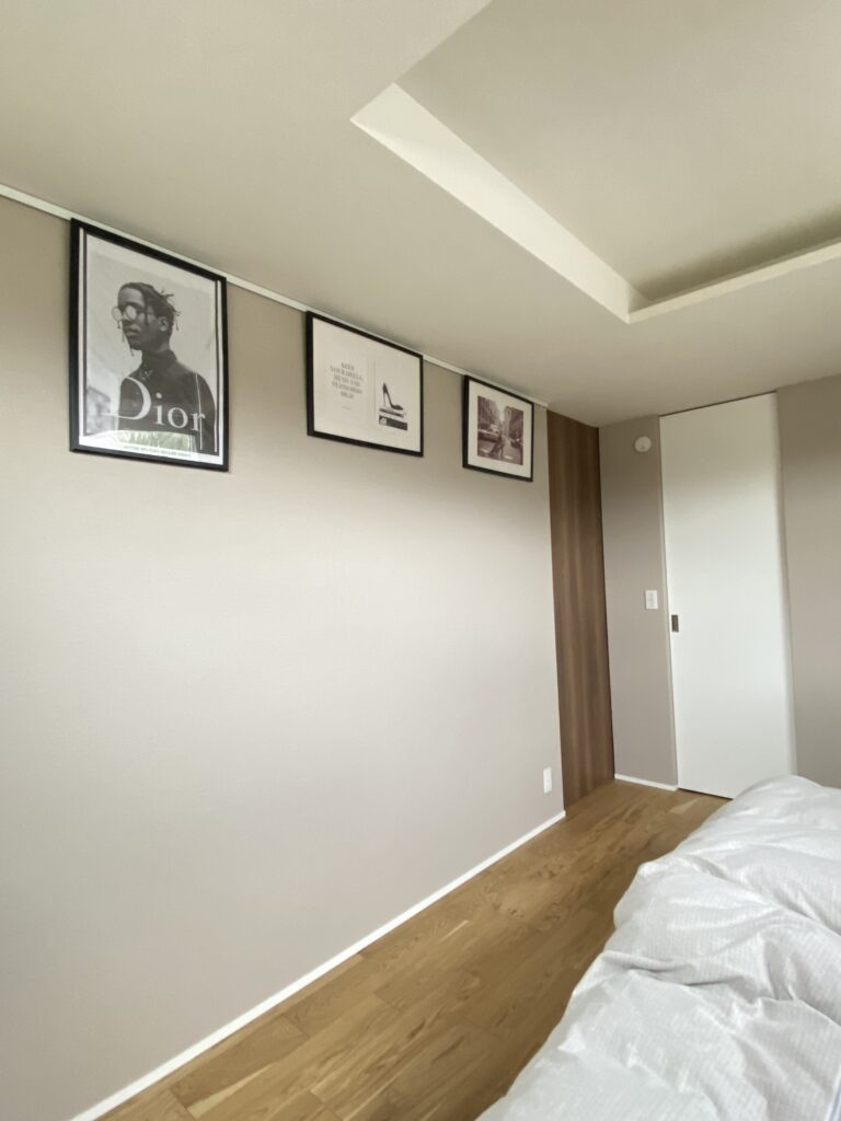 寝室壁の天井付近に３枚の黒縁ポスターが飾られている写真。