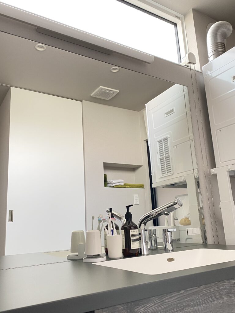 洗面所の鏡が映された写真。グレーの洗面台も映っている。
