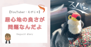 左側に「居心地の良さが問題なんだよ」というブログタイトルテキストがあり、右側にスパッとクールな様子で膝の上に立っているオニオオハシのぬいぐるみ”ねぐち”の写真がある。チャラ男とエビのイラストが小さく添えられている。