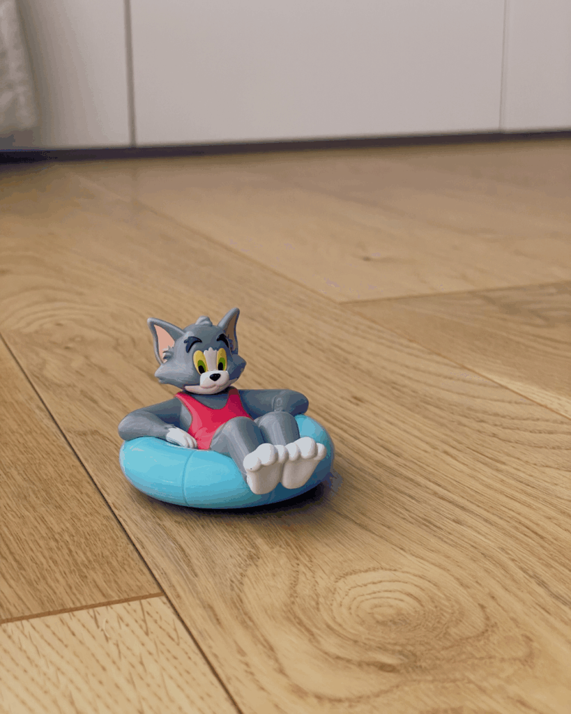 トムとジェリーのトムが浮き輪に乗っているフィギュアが床に置かれている写真。