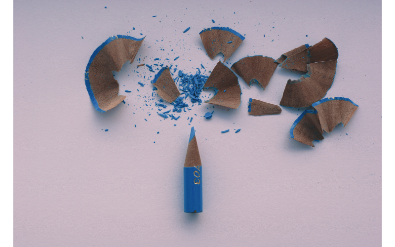 力がかかりすぎて折れてしまった青い鉛筆と削りカス。