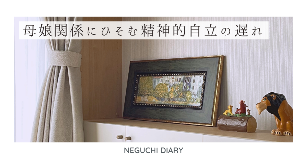 室内の棚に飾られた絵画と小さな置物。母娘関係に潜む精神的自立の遅れを考察する記事のイメージ。