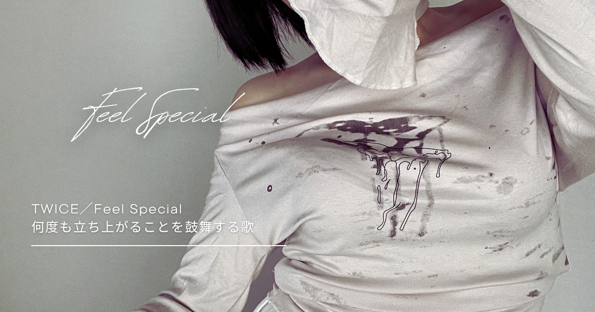 白いトップスの胸元にインクのような模様が広がり、少し崩れた質感が印象的な構図。肩を見せたポーズと「Feel Special」の文字が重なり、感情の揺れや再生を感じさせるビジュアル。
