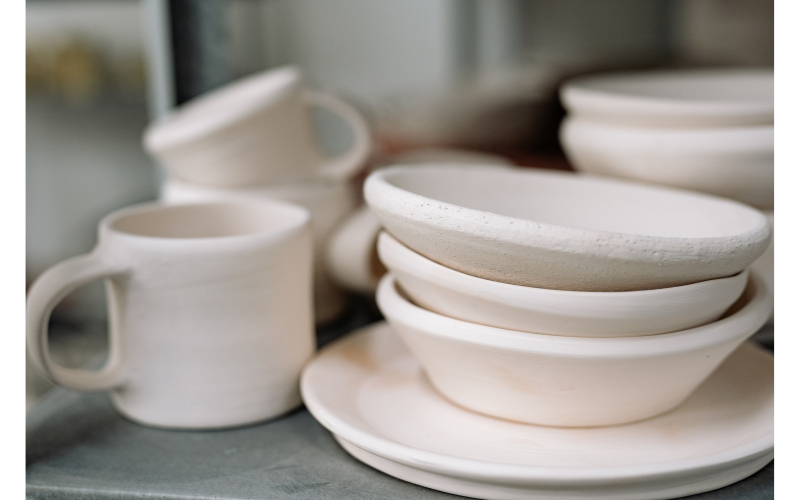 白い皿やカップが重ねられたシンプルな構図で、質感と静けさが伝わる落ち着いた写真。