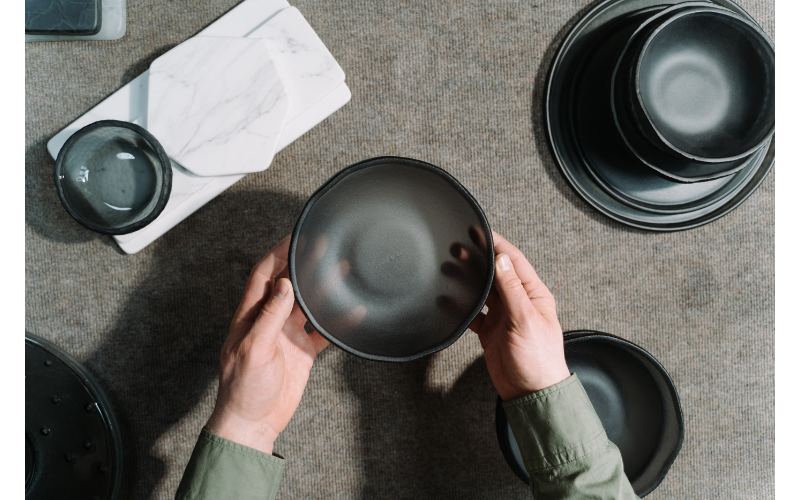 作業台の上で粘土をこねる手元を捉えた写真で、ものづくりの過程と集中した空気感が伝わる。