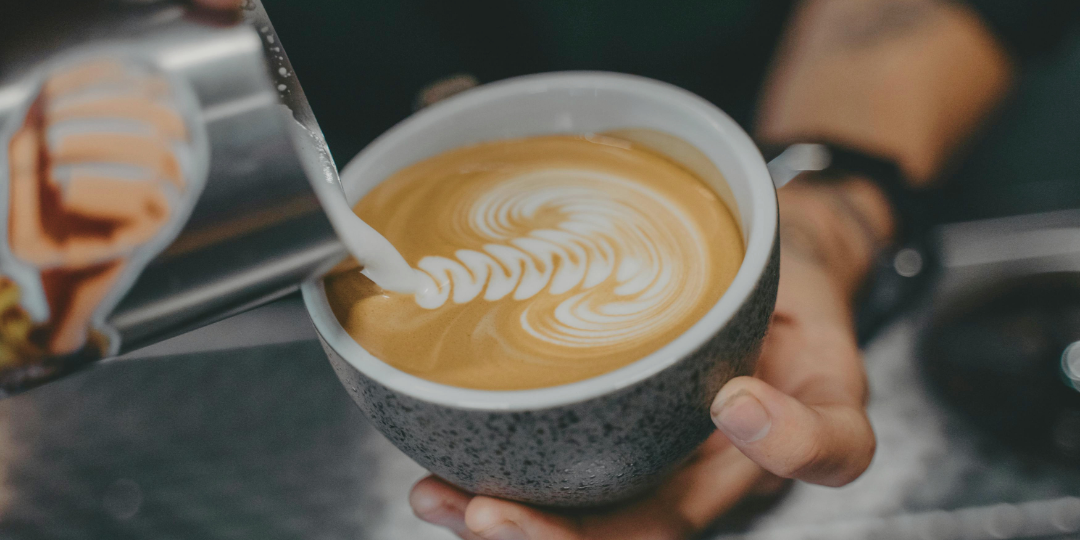 カップにミルクを注ぎ、ラテアートが形づくられていく様子。