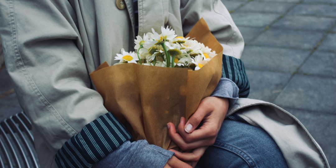 理想の暮らしや憧れなど、住宅購入の背景にある感情を象徴する花束を抱えた人物