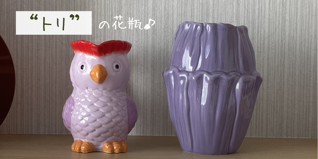 紫色の鳥モチーフの花瓶と、ラベンダー色の花瓶が並んで置かれている様子。「“トリ”の花瓶♪」という文字が添えられ、鳥好きのねぐちが気に入っている花瓶を紹介している。花のある暮らしと朝の水替え習慣のきっかけとなったアイテム。